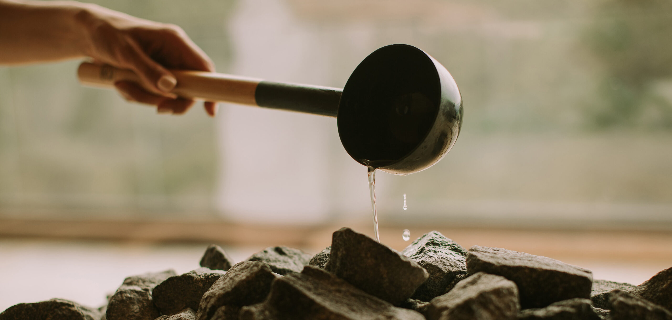 Pouring water over a sauna oven.
